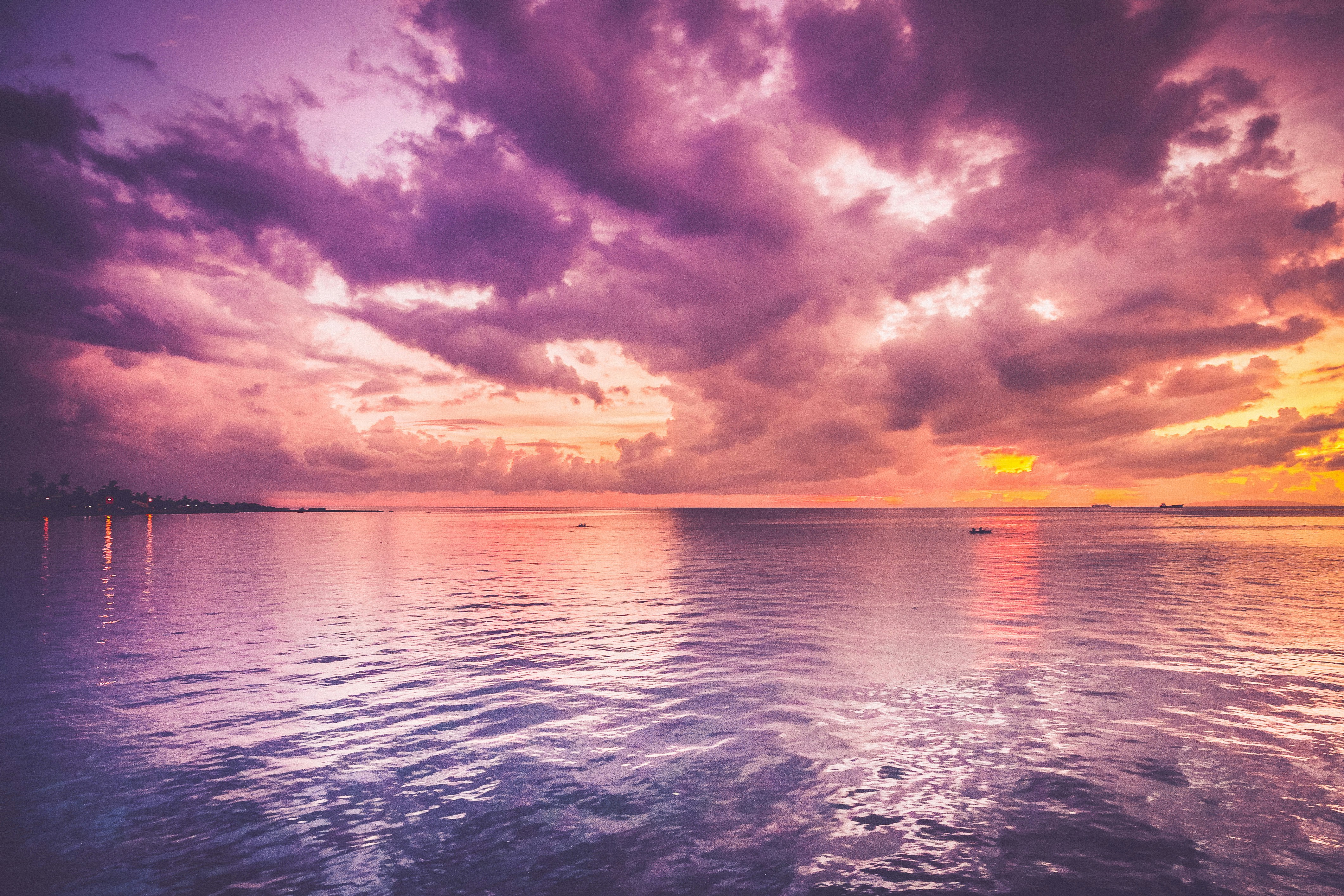 sunset through the clouds looking over the sea with vibrant orange and purple colours